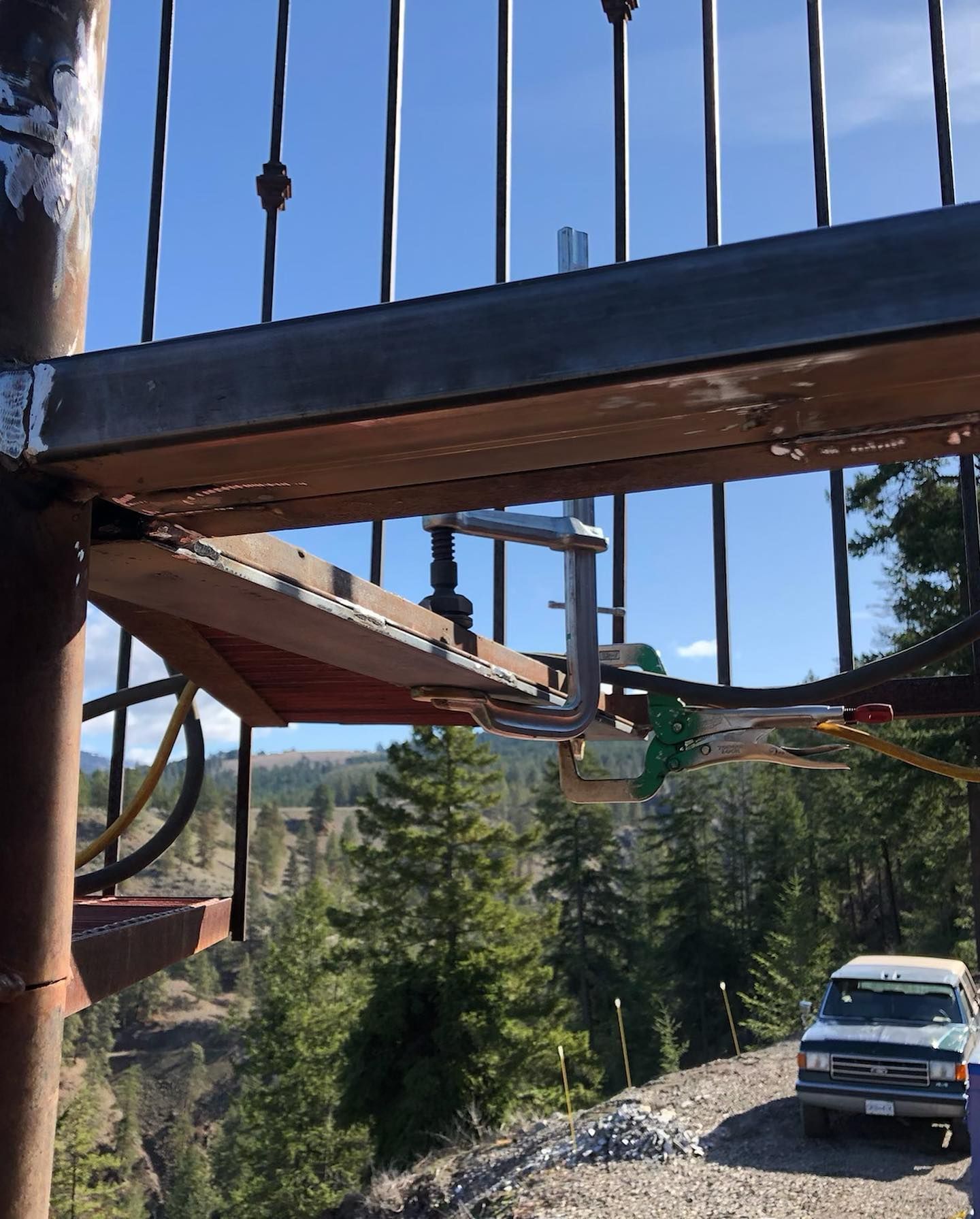 A truck is parked on the side of the road under a bridge