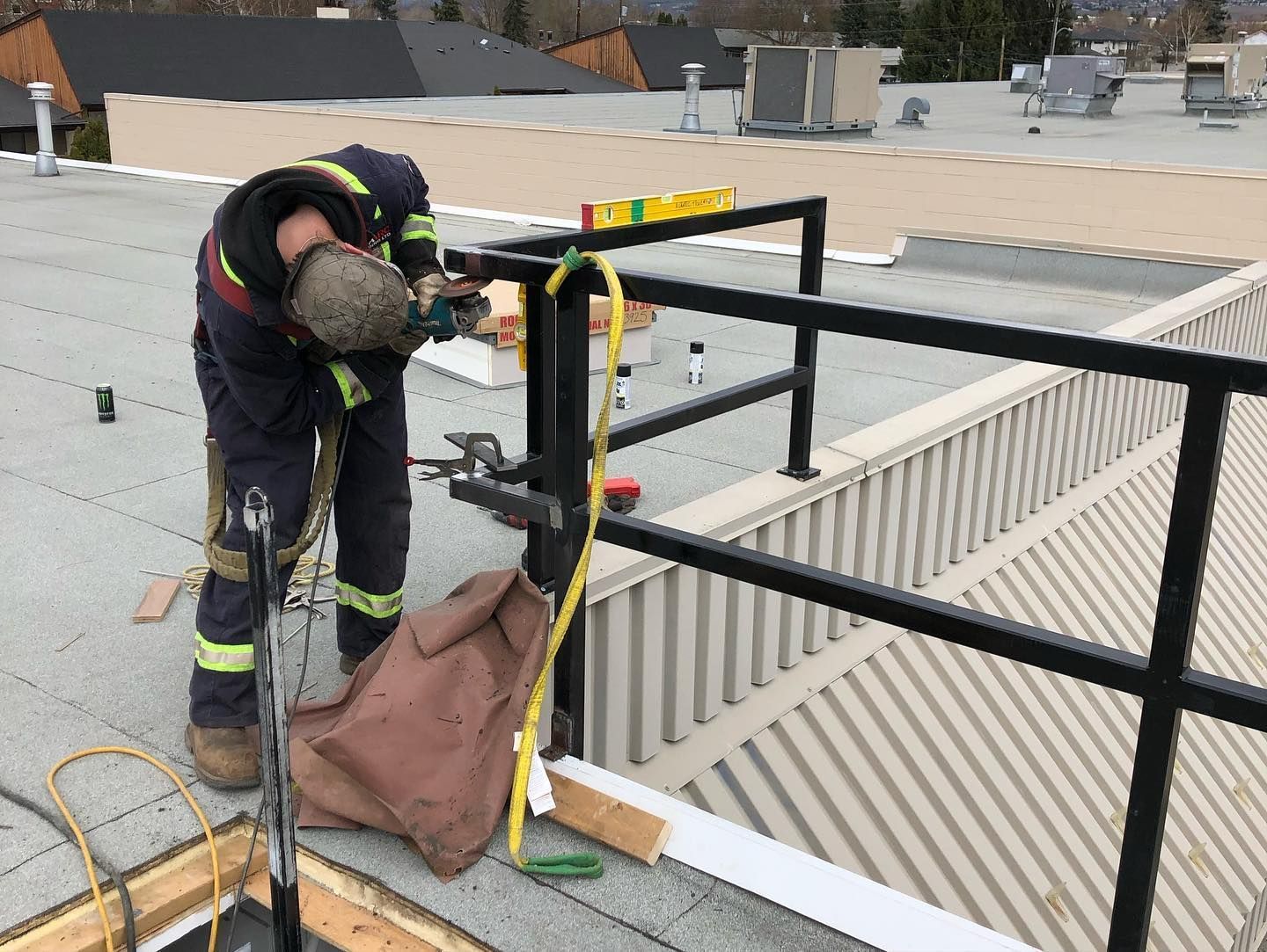 A man is working on a railing on the roof of a building.