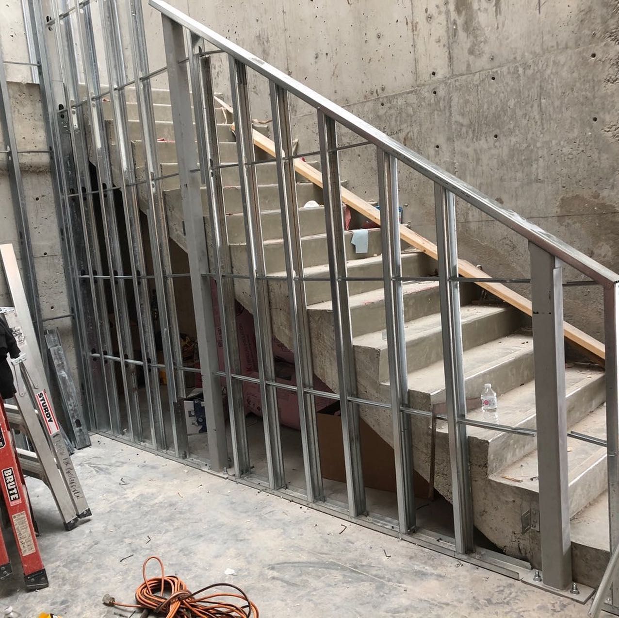 A staircase is being built with a metal railing