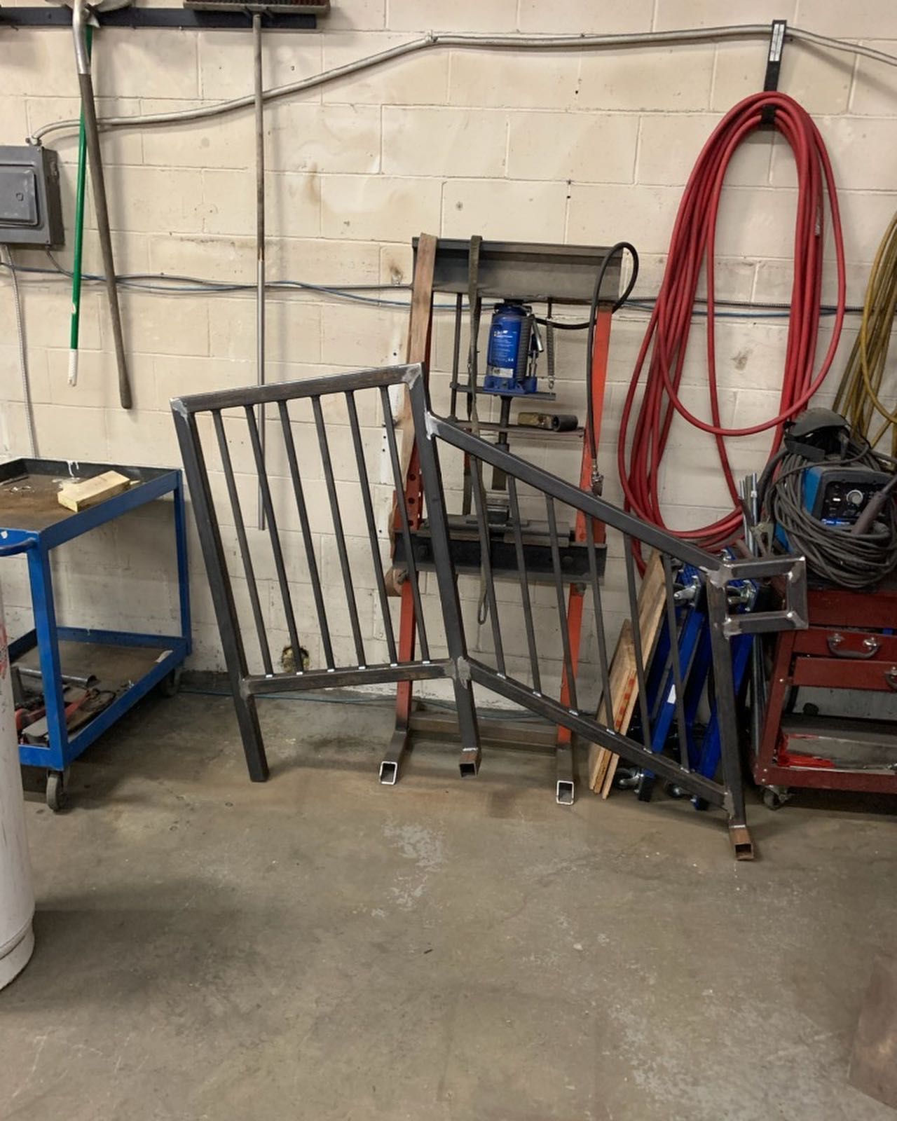 A metal fence is sitting on the floor in a workshop.
