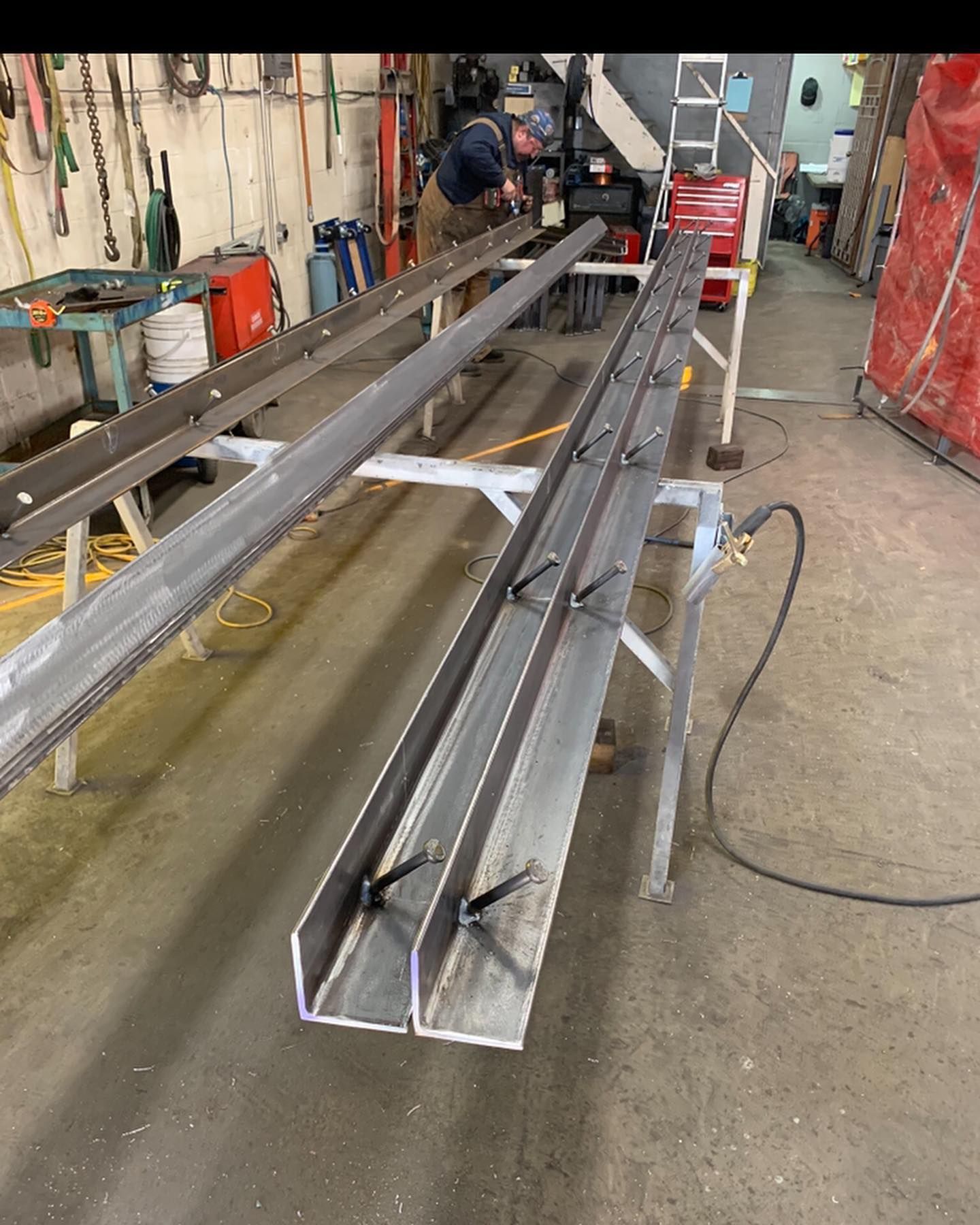A man is working on a piece of metal in a workshop.