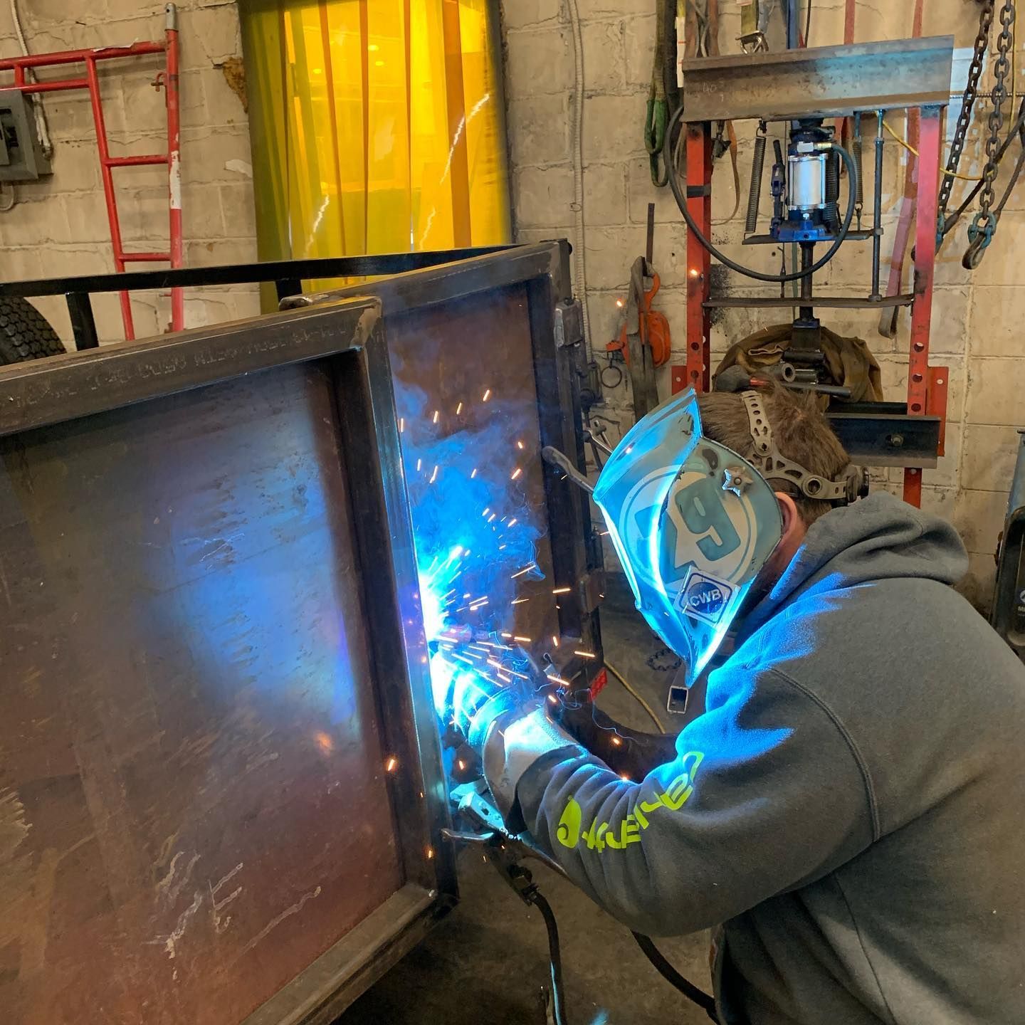 A man wearing a welding mask with the number 9 on it