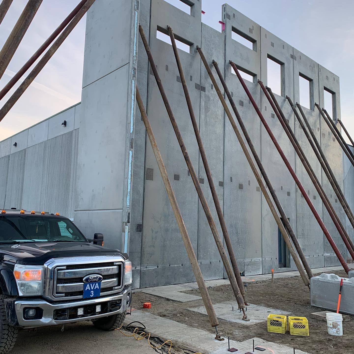 A ford truck is parked in front of a building under construction
