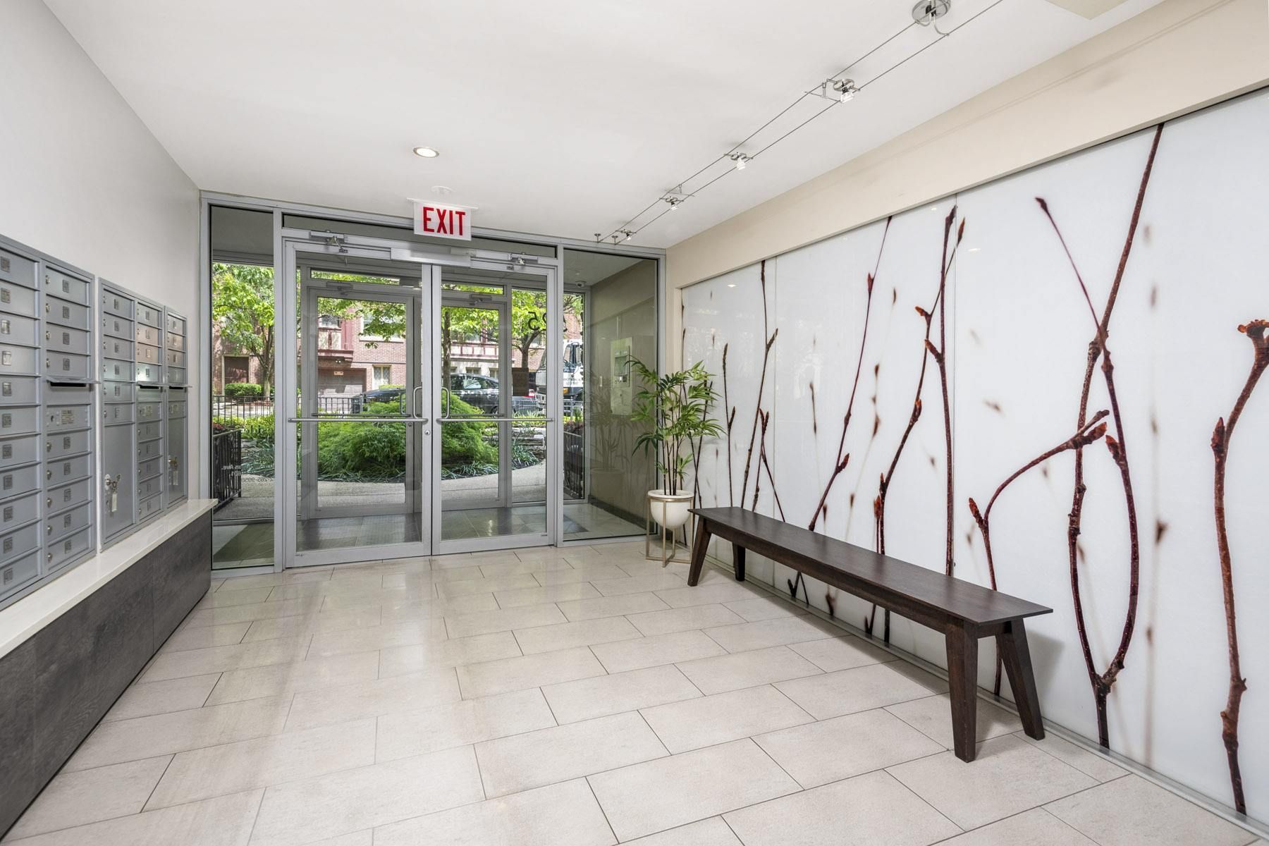 a hallway with a bench and exit doors