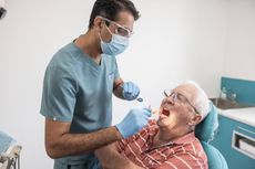 Dr Harry Ramana helping a client with their dentures