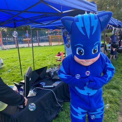 a person in a pj masks costume is standing in front of a computer