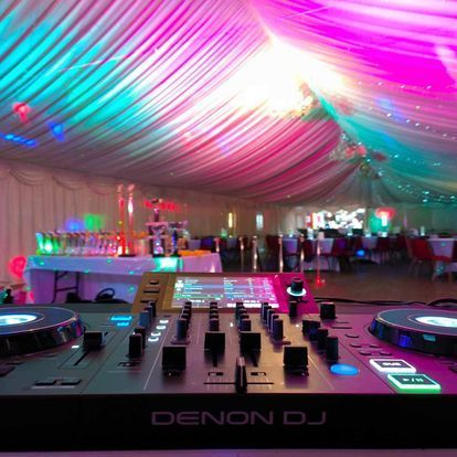 a denon dj mixer is sitting in a large room