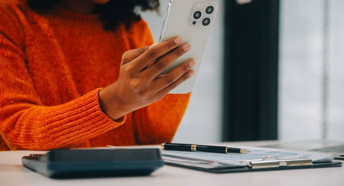 A woman in an office is looking at her mobile phone