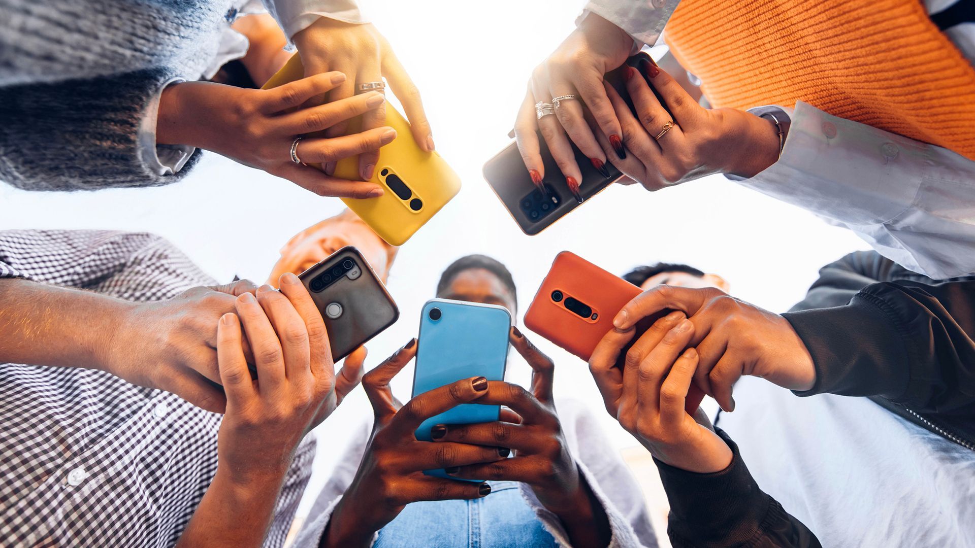 A group of people are looking at their mobile phones