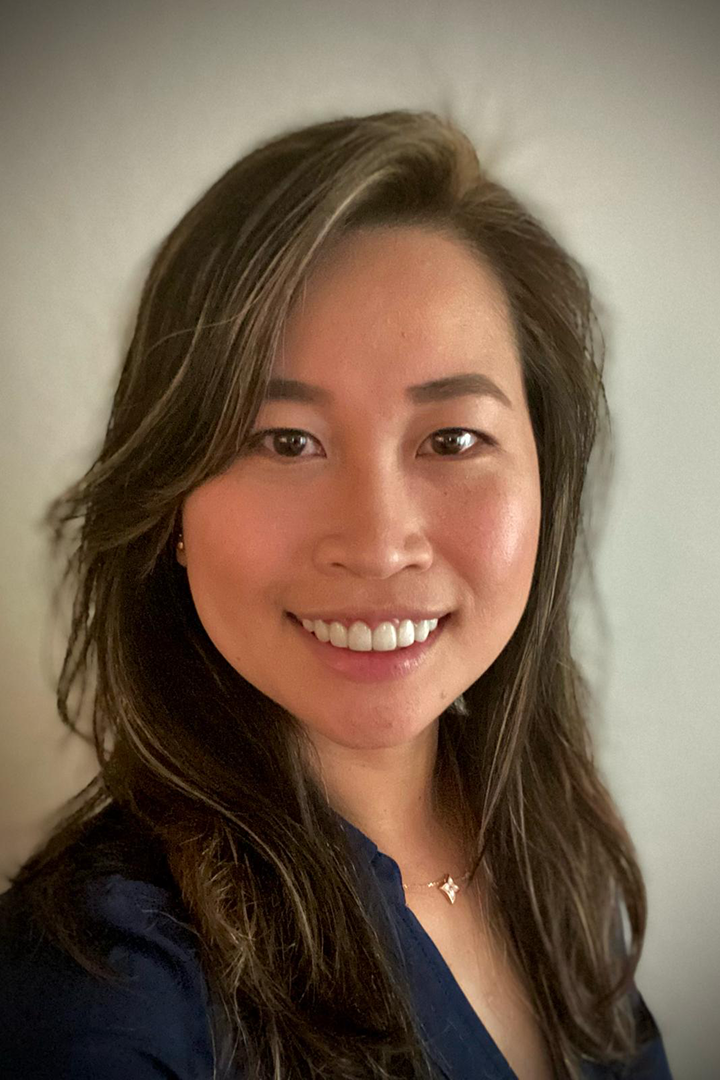 A woman with long hair is smiling for the camera.