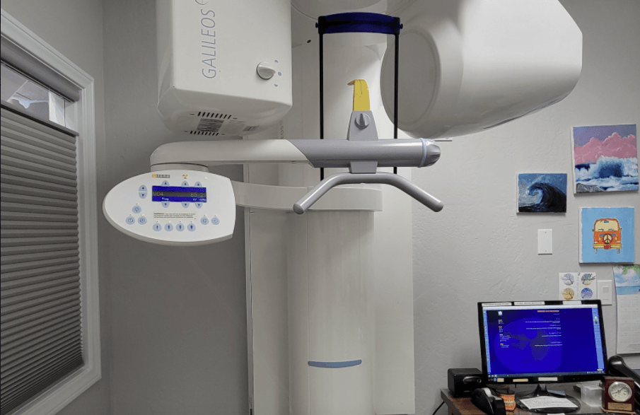 An x-ray machine is sitting in a room next to a computer.