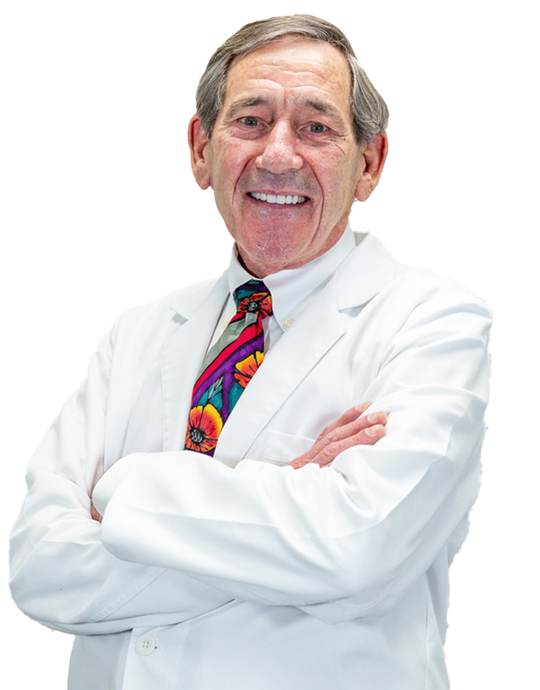 A man in a white coat and tie is smiling for the camera.