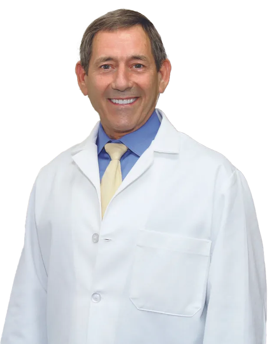 A man in a white coat and tie is smiling for the camera.