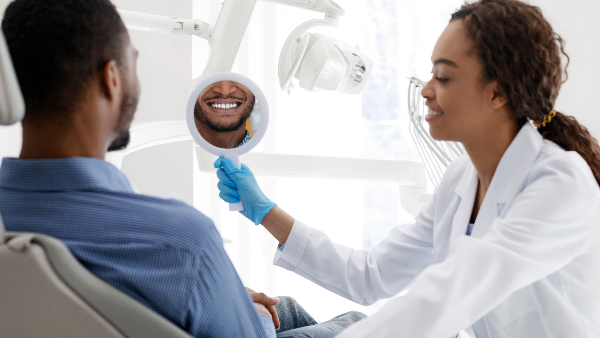 Dentist showing dental x-ray to patient in a bright clinic