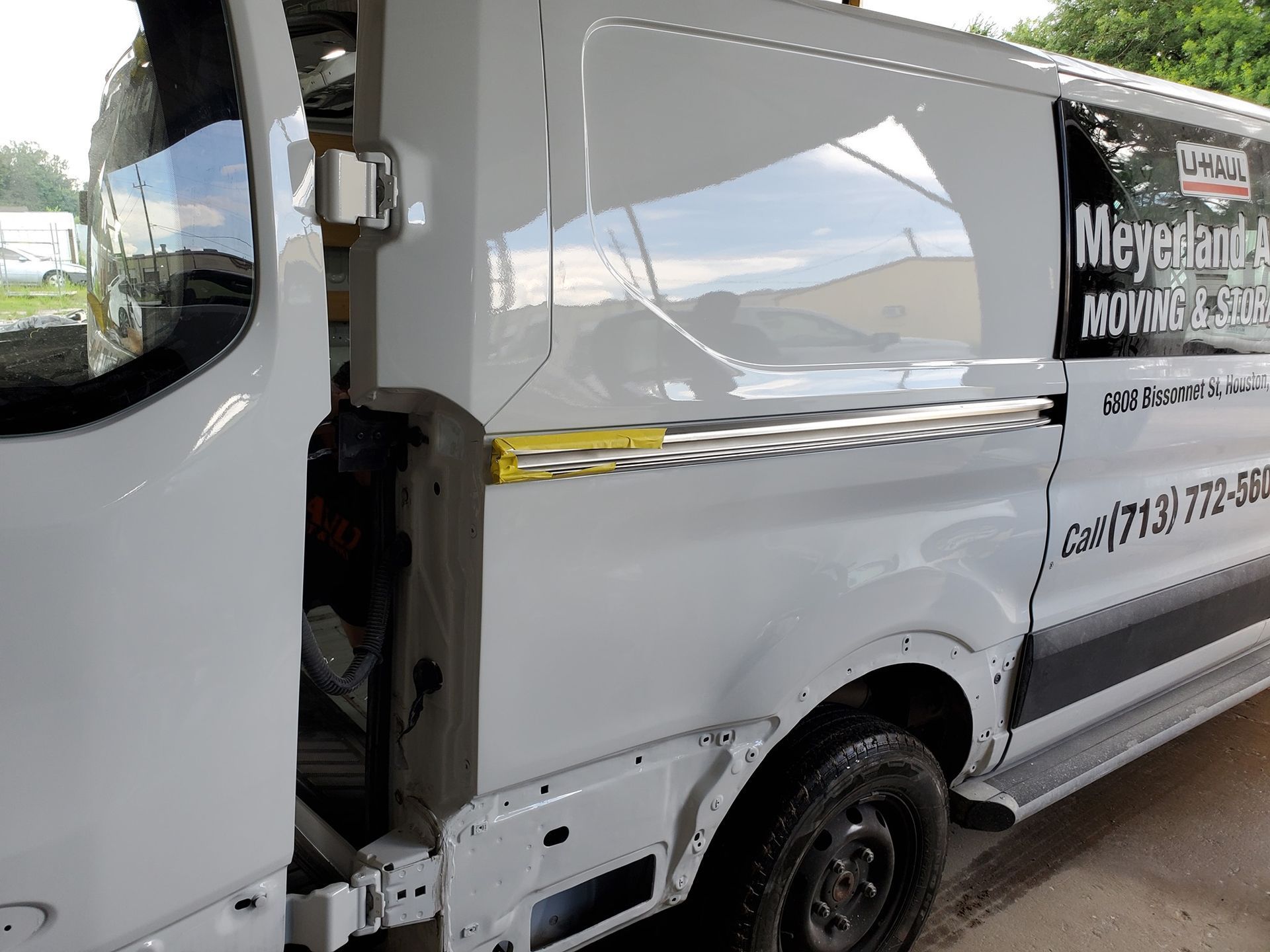 White van with open door, Meyer's Moving logo on side, parked outside.