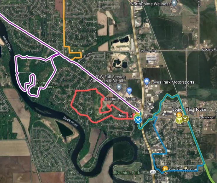 Satellite map with three highlighted route loops in purple, red, and teal around a river and town.