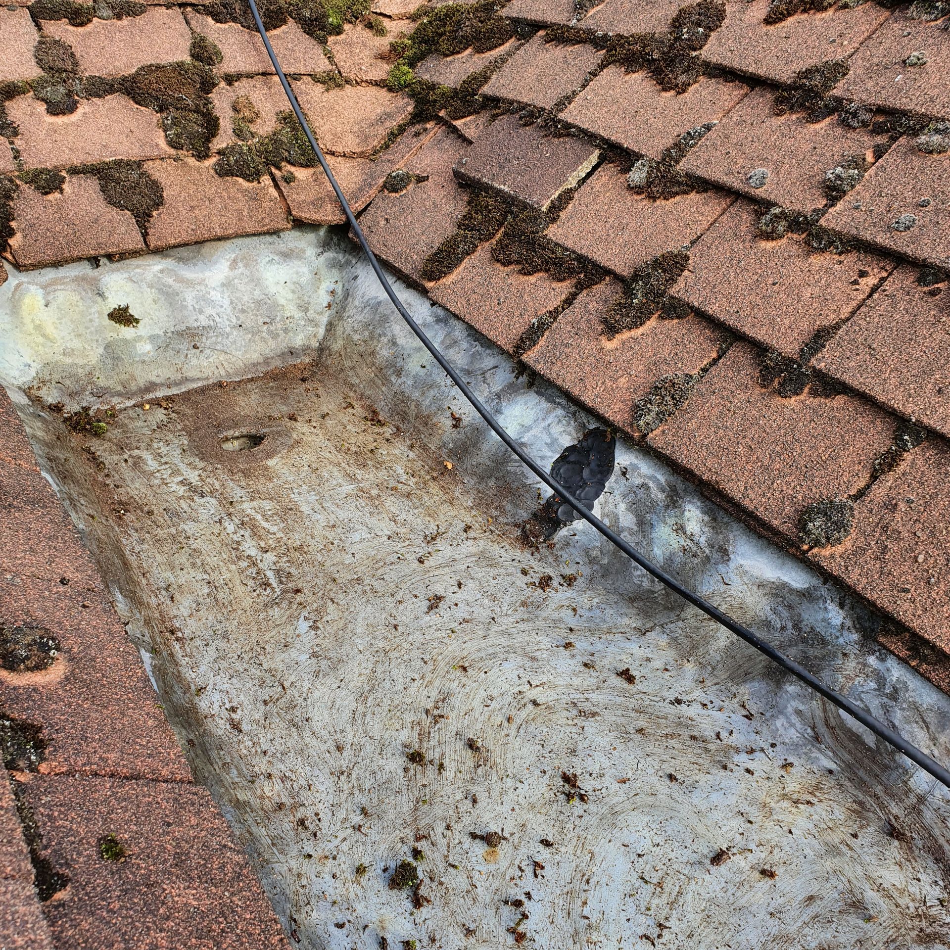 A close up of a roof with a drain on it.