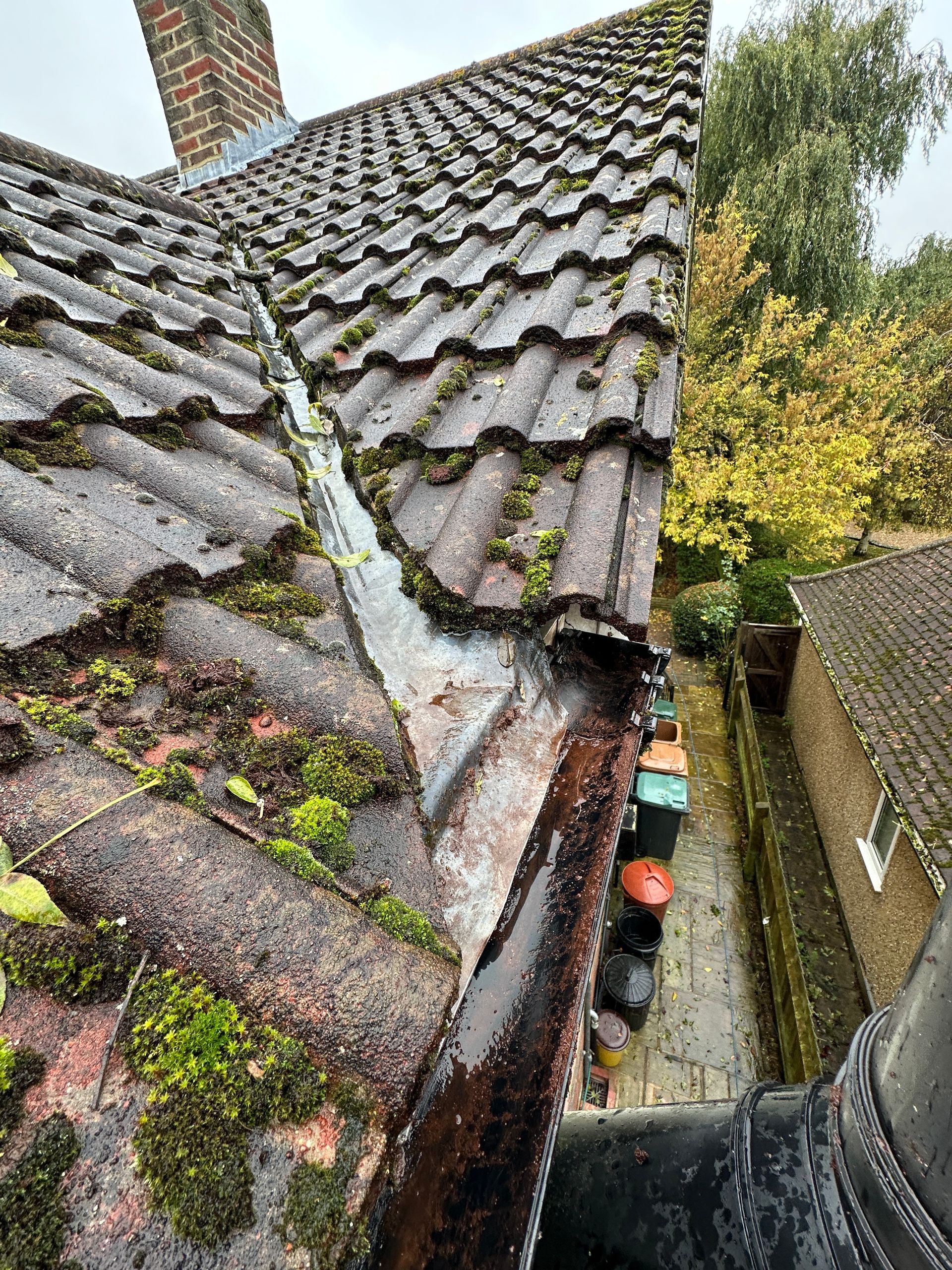 A gutter on the side of a roof that is empty.