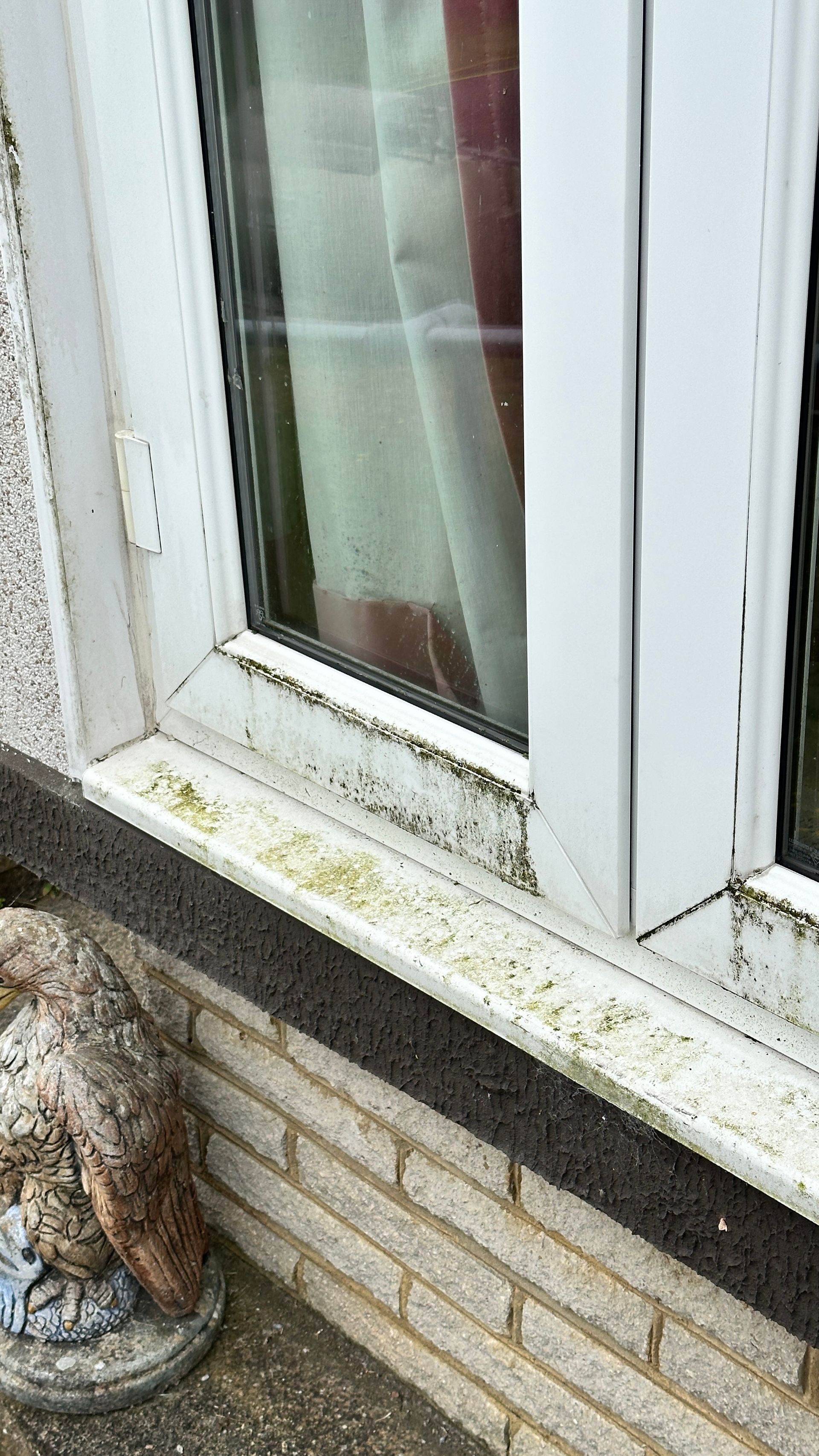 A close up of a dirty window sill on a brick wall.