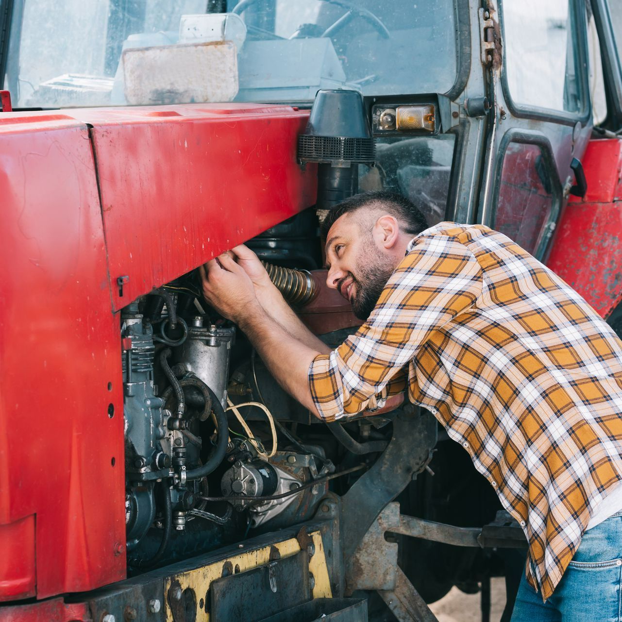 A man inspecting the tractor - Eugene, OR - The Tractor Store