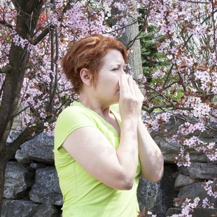 Woman covering her mouth as she sneezes