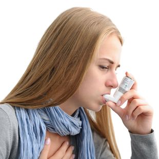 Young woman using an inhaler