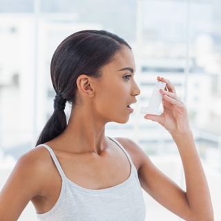 Woman using inhaler.