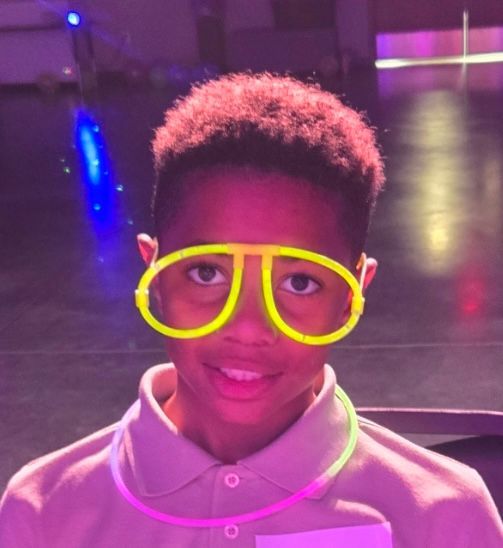 A young boy wearing glow in the dark glasses
