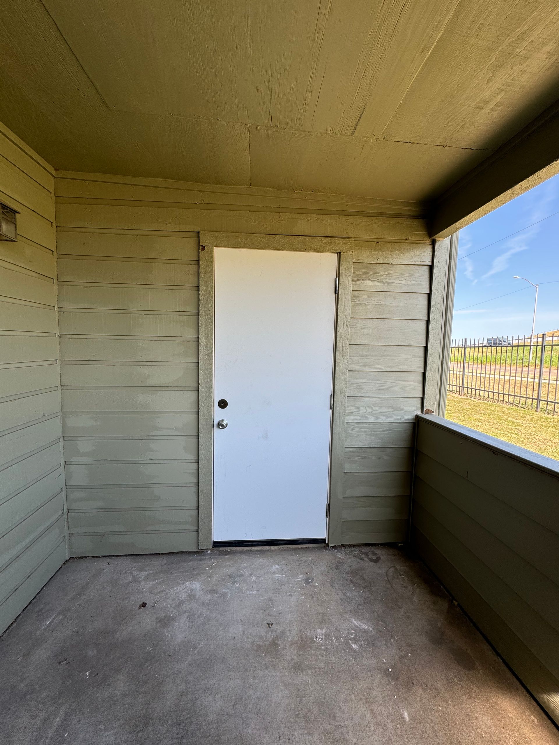 An empty room with a white door and a window