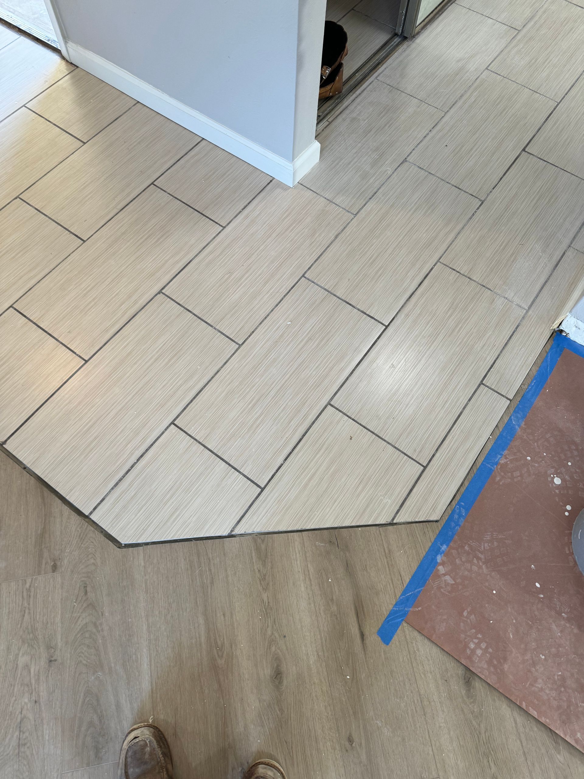 A person is standing on a tiled floor in a room.