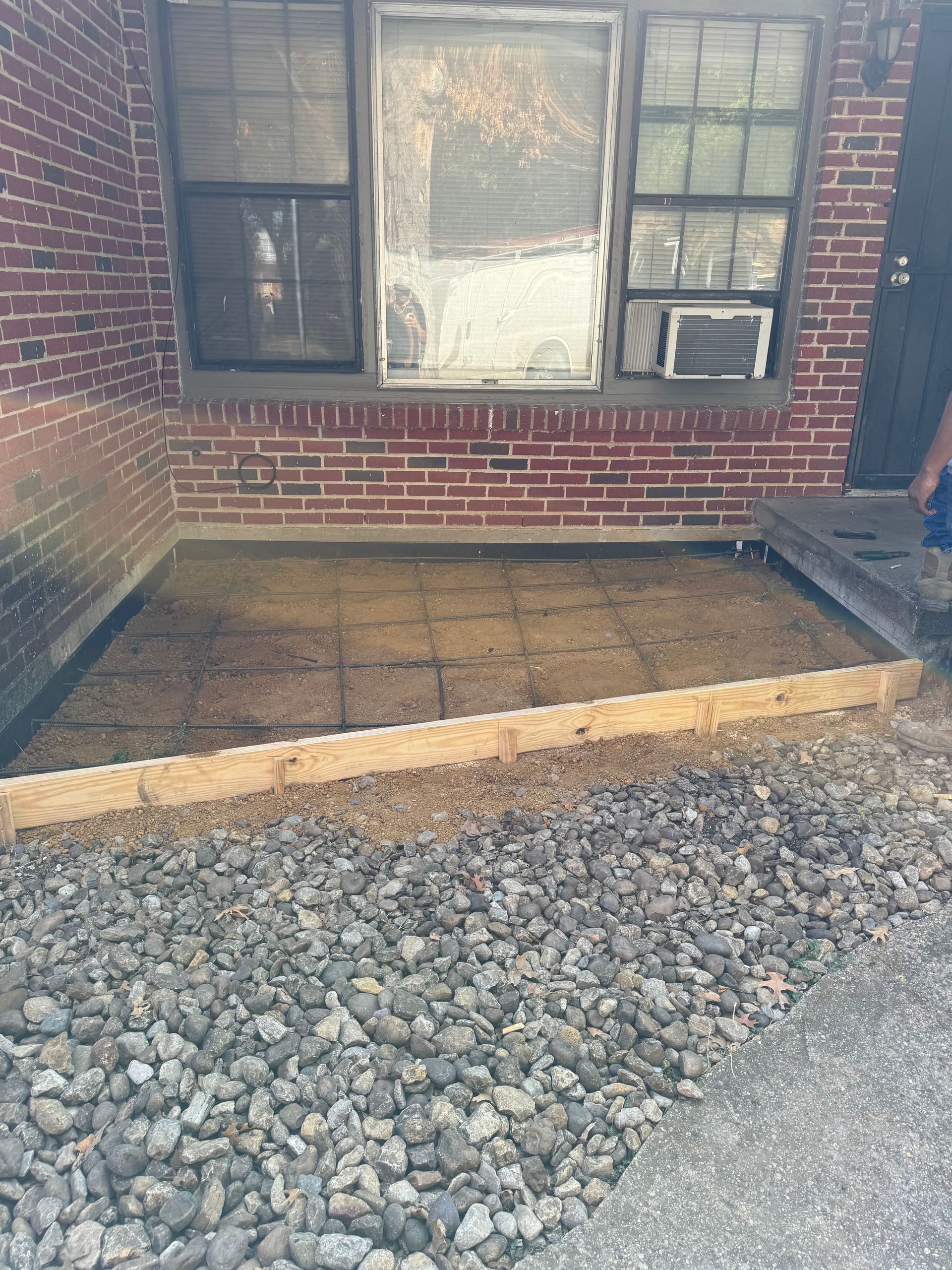 A person is standing in front of a brick building