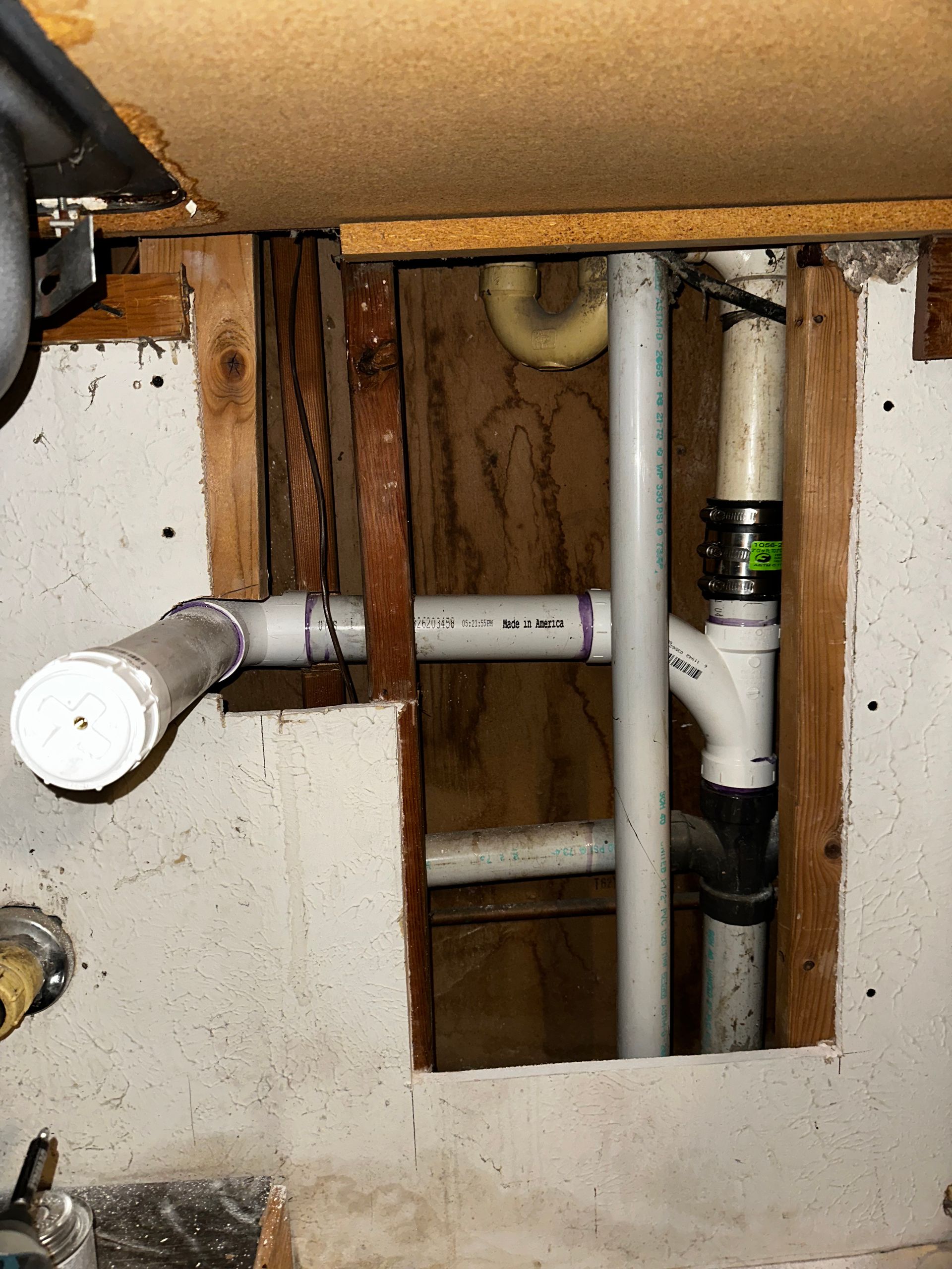 A hole in a wall with pipes coming out of it