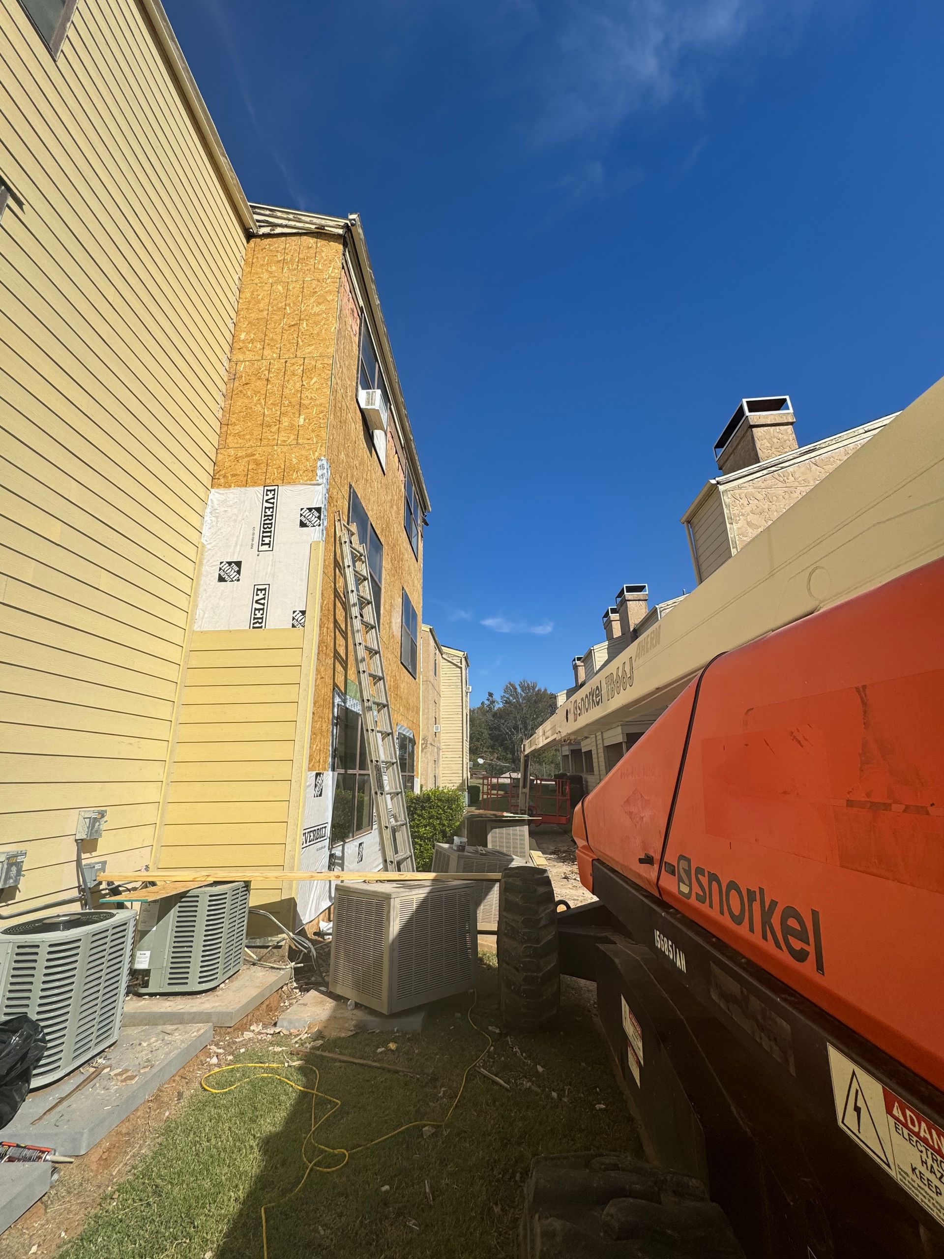 A jlg crane is parked in front of a building under construction
