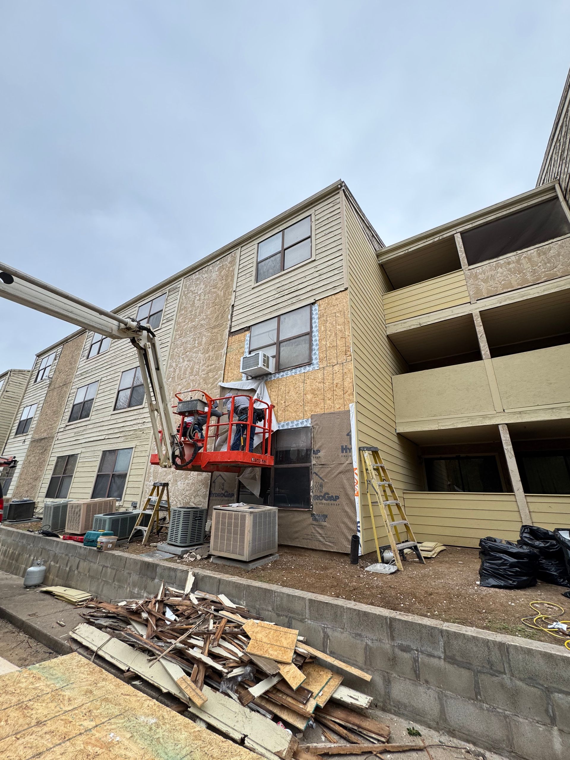 A large building under construction with a crane in front of it.