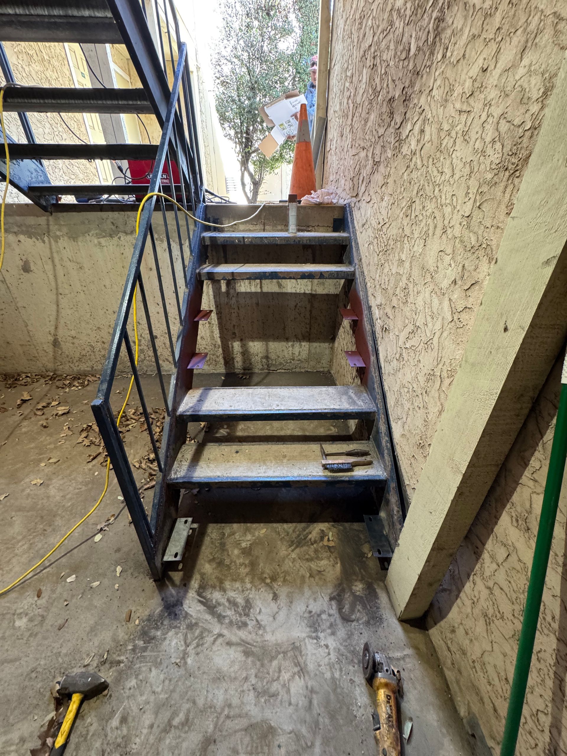 A metal staircase is being built on the side of a building.
