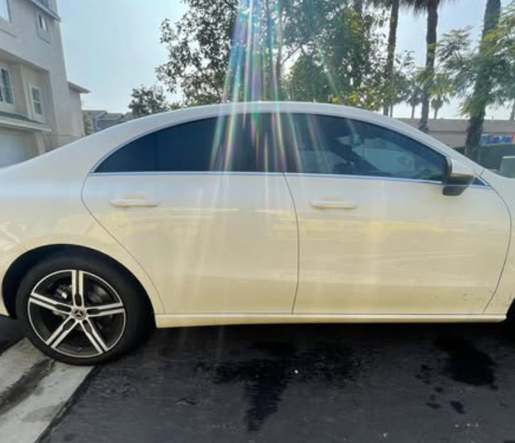 A white car is parked on the side of the road