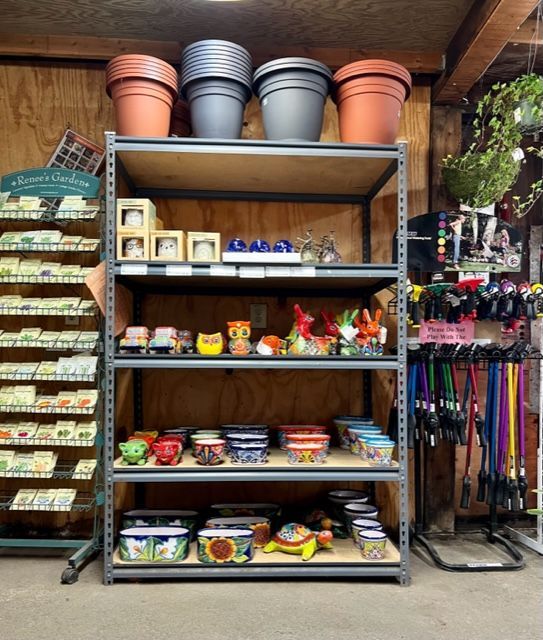 Shelving unit in a garden store displaying pots and decorative items.