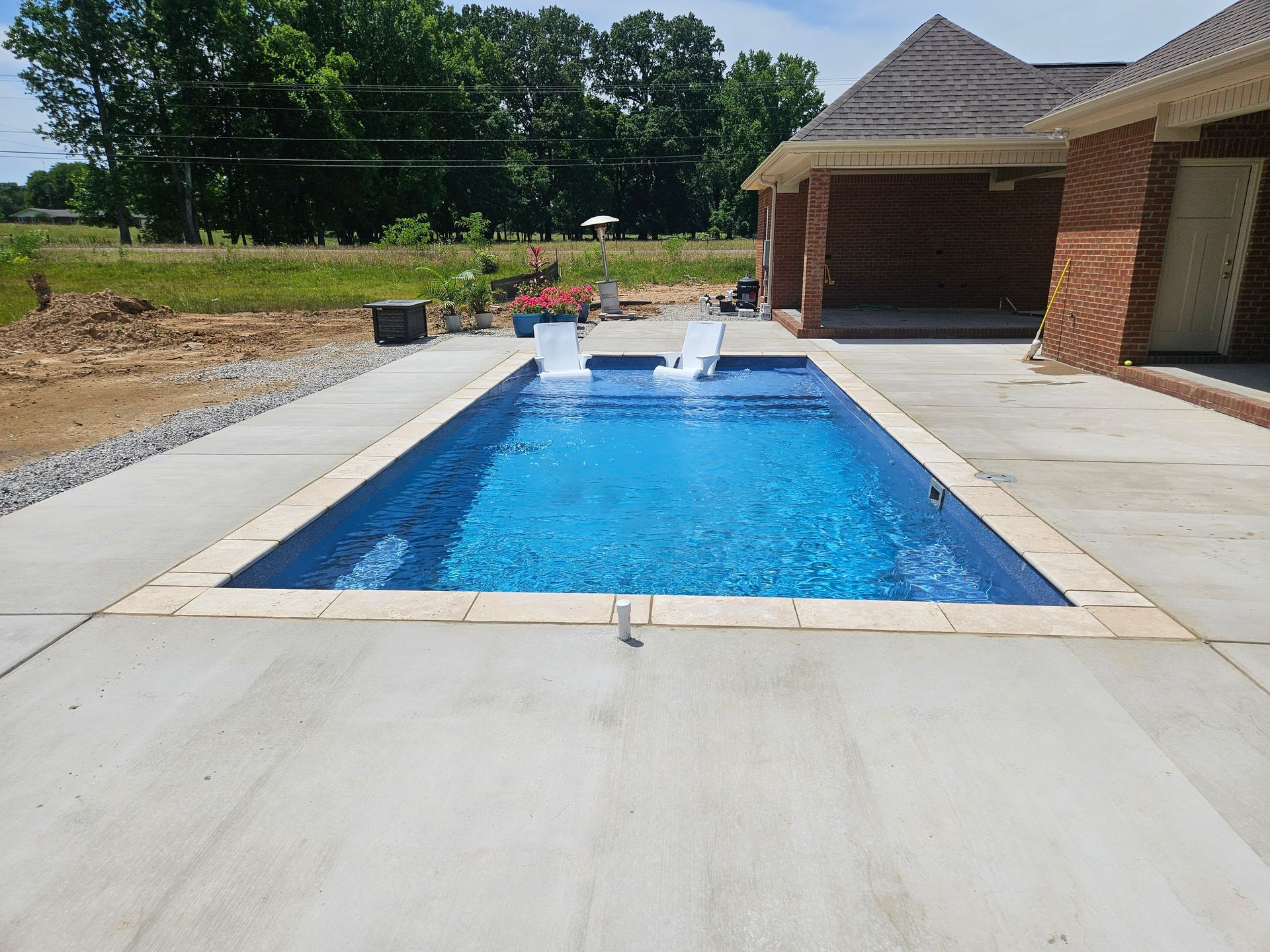 A large swimming pool is being built in a backyard.