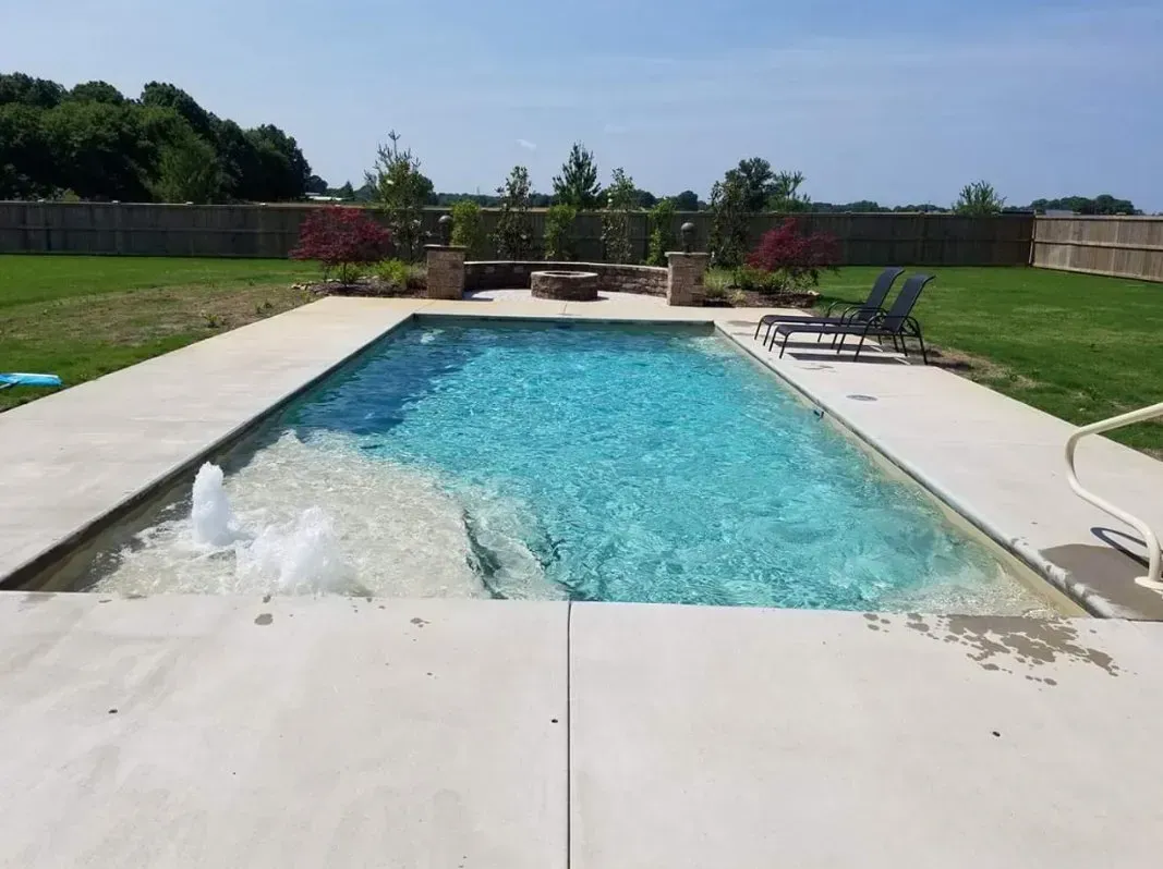 A large swimming pool with a fountain in the middle of it