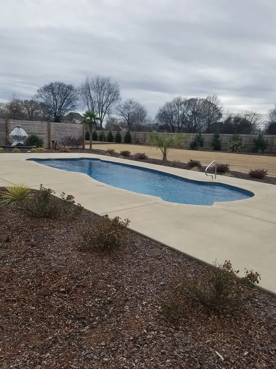 There is a large swimming pool in the backyard.