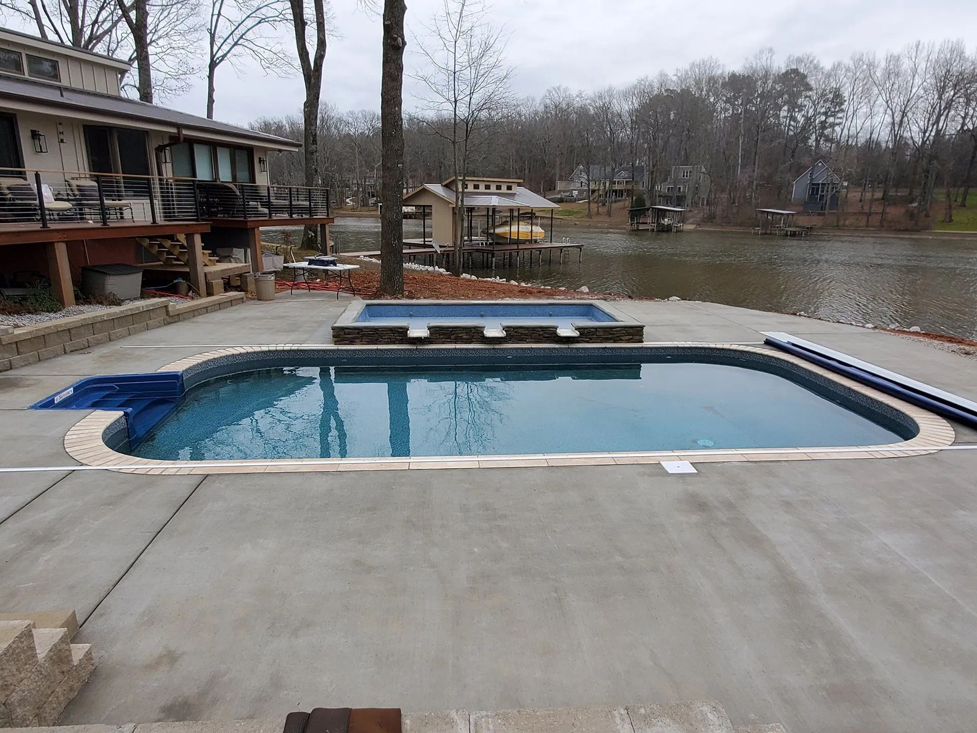 A large swimming pool with a house in the background