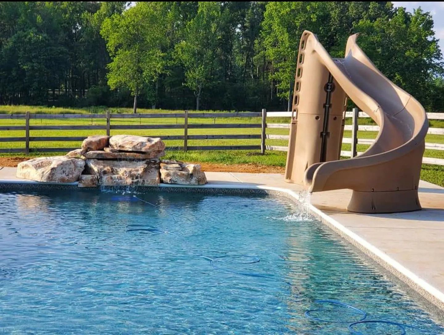 A swimming pool with a slide and a waterfall
