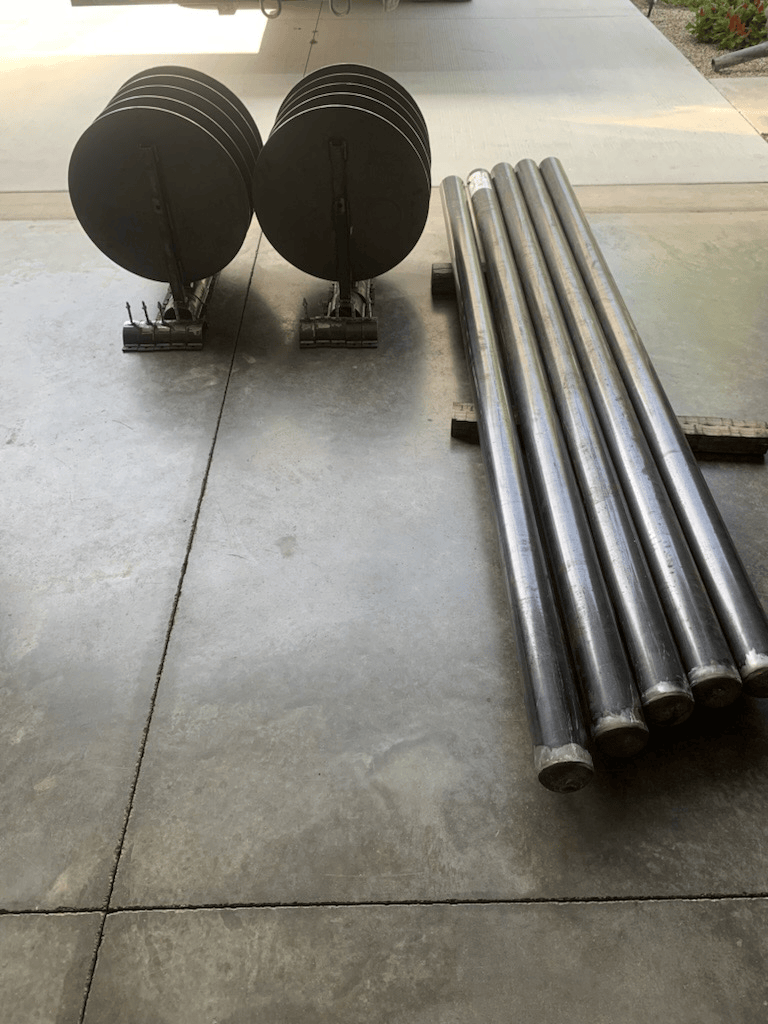 A stack of metal pipes sitting on top of a concrete floor.
