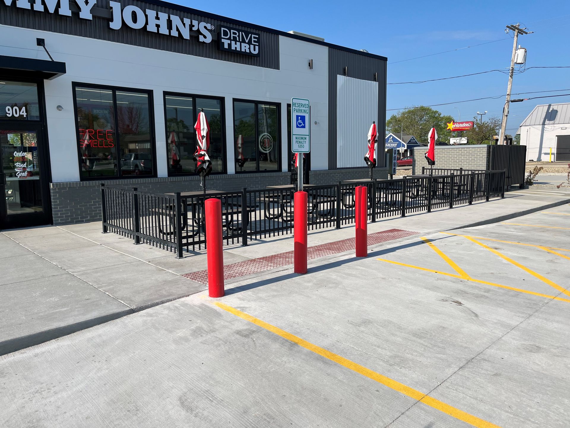 A parking lot in front of a restaurant with tables and chairs.