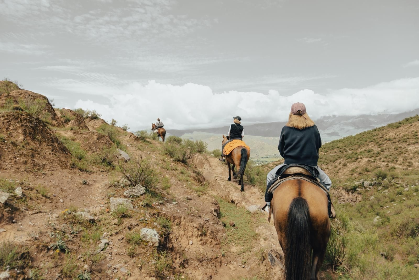 Botas de montaña caminando por un camino de tierra, primer plano con un resplandor de hora dorada.