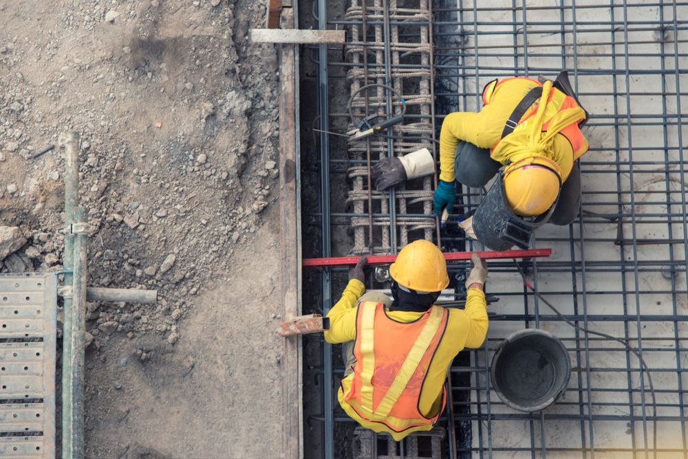 Two Construction Workers in Yellow Vests and Hardhats Working on Rebar — ALI Civil Pty Ltd in Wollongong, NSW