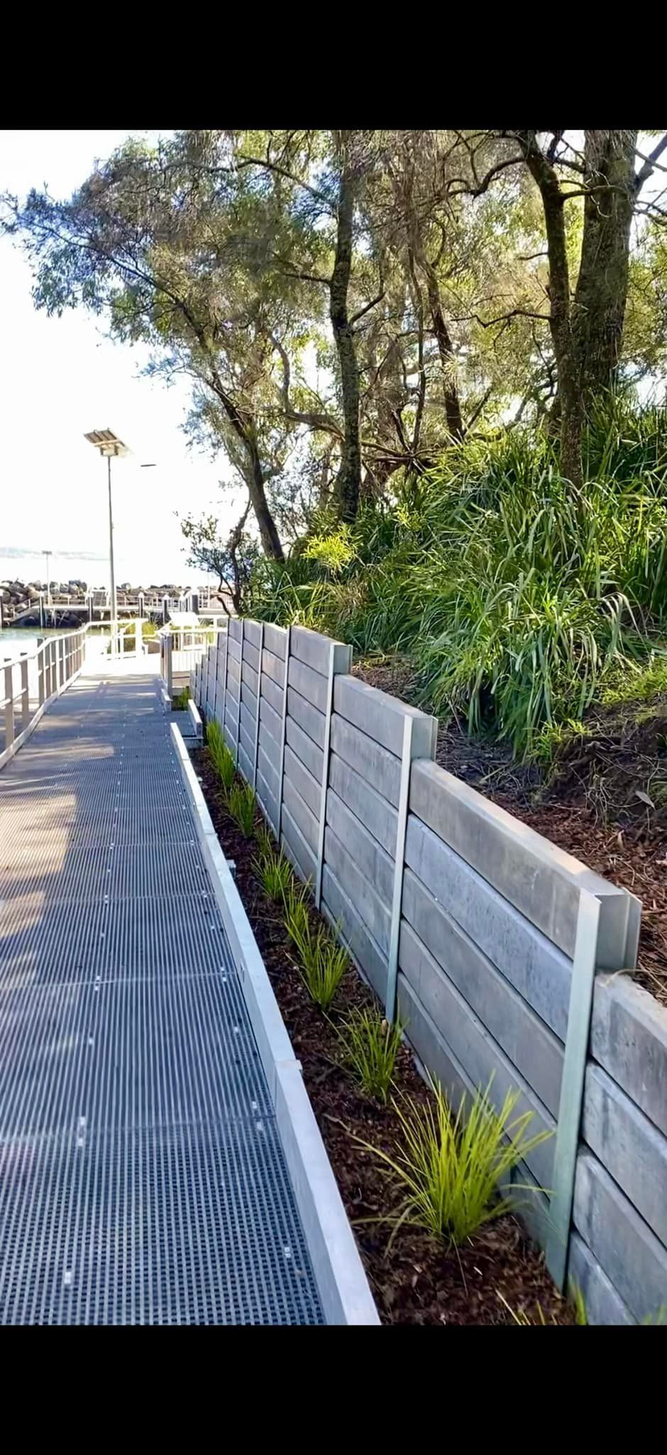 A Walkway Next to a Retaining Wall With Trees  — ALI Civil Pty Ltd in South Ulladulla, NSW