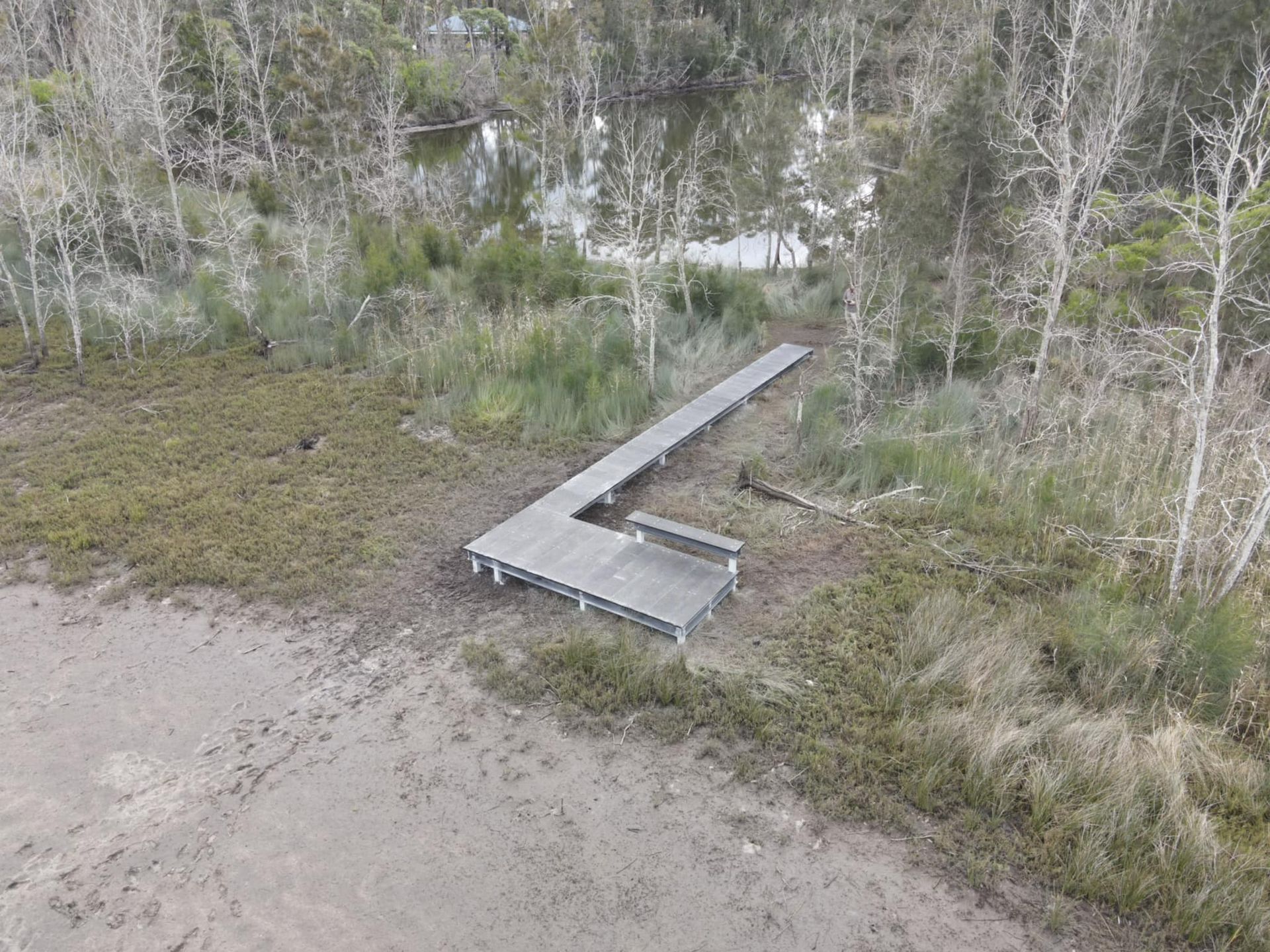 A Wooden Pier Extends Into a Muddy Area, Leading Towards Trees — ALI Civil Pty Ltd in South Nowra, NSW