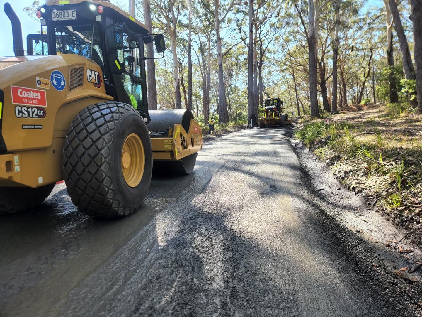 Yellow Road Roller Compacts Asphalt Road; Another Machine in the Distance — ALI Civil Pty Ltd in Ulladulla, NSW