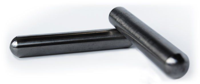 Two black rods are sitting on top of each other on a white surface.